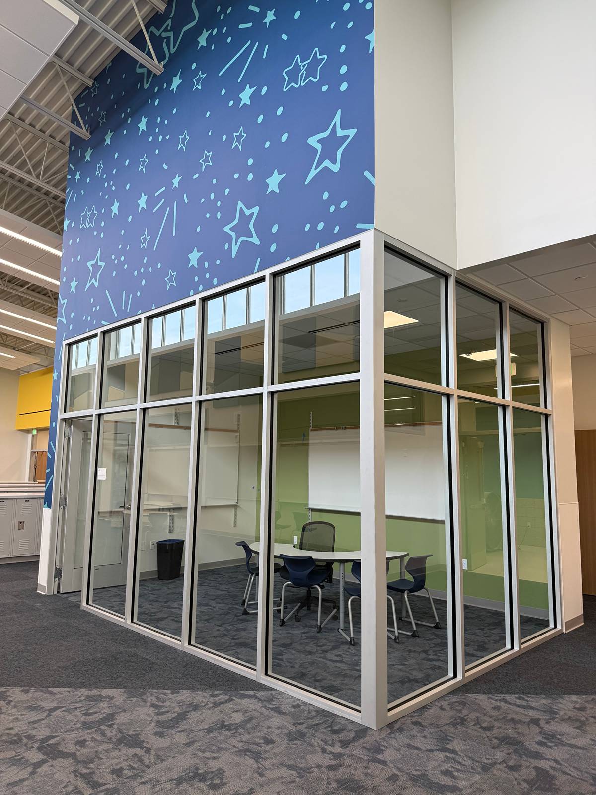 Glass-walled study room under a starry blue mural, with clean glass and carpet